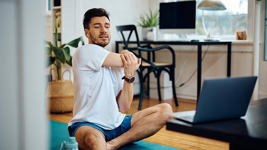 Adult man doing stretches on living room floor